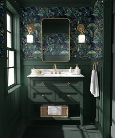 a bathroom with green walls and floral wallpaper, gold fixtures and two sinks in front of a mirror