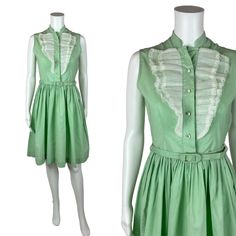 Vintage 1950s Mint Green Dress Women's Extra Small Sleeveless Ruffle Bib Belted Shirtdress You'll look as sweet as a scoop of mint ice cream in this darling 1950s shirt dress! This vintage beauty is a lovely shade of mint green with a white ruffle detail on the bodice, rhinestone buttons and a fitted waist with matching belt. Vintage dress zips up the side with a metal zipper. LABEL: - FABRIC: feels like cotton  MARKED VINTAGE SIZE: - SHOULDERS: 13.5" SHOULDER TO WAIST: 14.5" BUST: 35" WAIST: 26 1950s Style Sleeveless Green Dress, 1950s Ruffled Vintage Dress For Spring, 1950s Vintage Summer Dress With Ruffles, 1950s Vintage Ruffled Dress For Summer, 1950s Style Vintage Ruffled Dress For Summer, Spring Sleeveless Vintage Dress, Sleeveless Vintage Dress For Spring, Green Sleeveless Retro Vintage Dress, Retro Sleeveless Vintage Dress With Ruffles