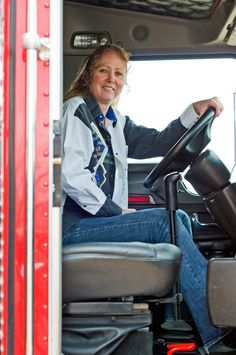 a woman sitting in the driver's seat of a truck