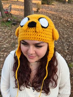 a woman wearing a yellow hat with eyes drawn on it