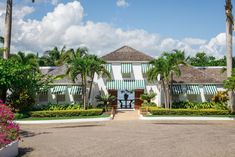 a large white house surrounded by palm trees