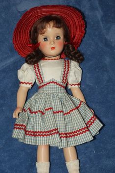 the doll is wearing a red hat and dress