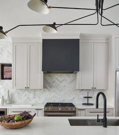 a kitchen with white cabinets and black appliances