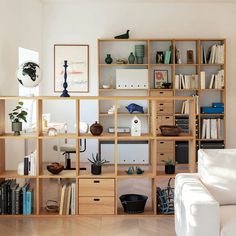 a living room filled with lots of furniture and bookshelves on top of each other