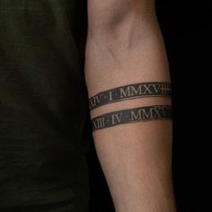 a man with a tattoo on his arm has roman numerals tattooed on it