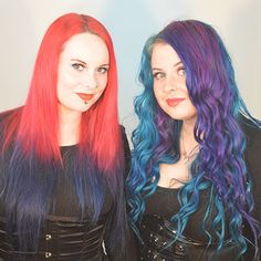 two women with colorful hair standing next to each other in front of a white wall