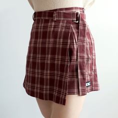 Plaid shorts with a belted skirt overlay and concealed side zipper. S: 26" waist, 15.5" length M: 27.5" waist, 15.5" length L: 29" waist, 15.5" lengthXL: 30.5" waist, 16" length2XL: 32" waist, 16" length3XL: 33.5" waist, 16" length4XL: 35" waist, 16.5" length5XL: 36.5" waist, 16.5" length Casual High Waist Shorts With Belt Detail, Fall Asymmetrical Skirt With Belt Loops, Summer Asymmetrical Skirt With Belt Loops, Chic Bottoms With Belt Loops And Asymmetrical Hem, Fall Short Skirt With Belt Loops, Spring Bottoms With Belt Loops And Asymmetrical Hem, Red Fitted Bottoms With Asymmetrical Hem, Trendy Short Skirt With Belt Loops, Casual Red Bottoms With Asymmetrical Hem