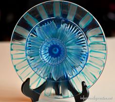 a blue glass plate sitting on top of a wooden stand