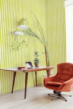 an orange chair sitting in front of a wooden table