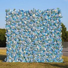 a large blue and white flowered wall on the side of a road