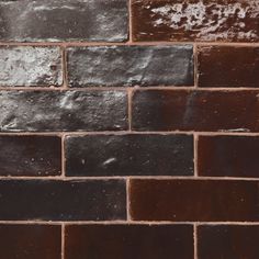 a brick wall that is made out of different colors and shapes, with some rust on it