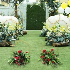 an outdoor ceremony with flowers and balloons on the grass in front of it, surrounded by greenery