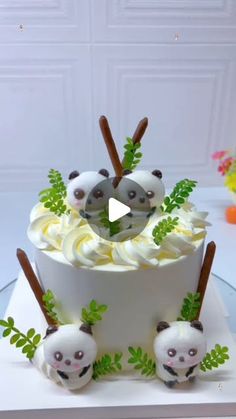 the cake is decorated with pandas and green leaves