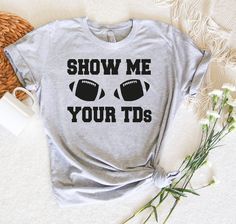 a t - shirt with the words show me your tids on it next to some flowers