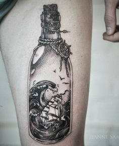 a black and white photo of a bottle with a ship in it