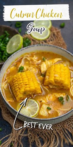 an image of a bowl of soup with corn on the cob and limes