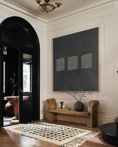 an image of a living room with black and white decor on the walls, windows, and rugs