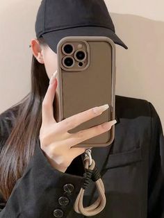 a woman holding up her phone case to take a selfie with her hat on