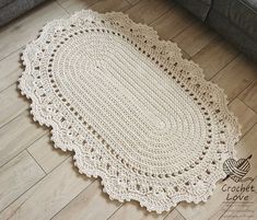 a crochet doily is laying on the floor in front of a couch