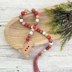 a wooden beaded necklace with a red and white striped cord on a wood board