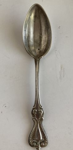 an antique silver spoon on a white background