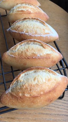 four loaves of bread cooling on a rack