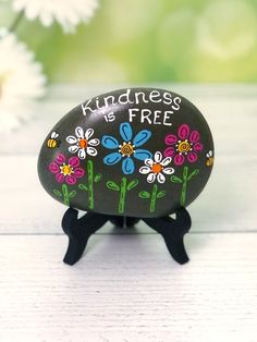 a painted rock sitting on top of a wooden table