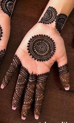 two hands with henna tattoos on them