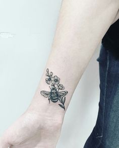 a small bee tattoo on the wrist