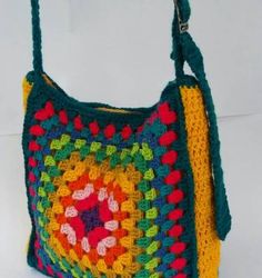 a multicolored crocheted bag with handles