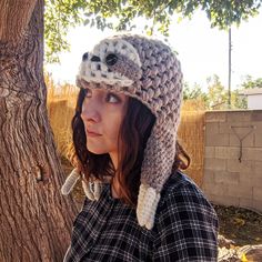 a woman wearing a crocheted hat with an owl on it