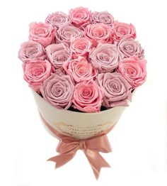 a bouquet of pink roses in a white vase