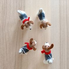 four small stuffed animals sitting on top of a wooden table