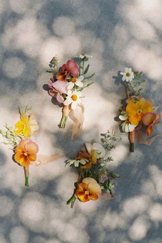 four boutonnieres are arranged in the shape of flowers