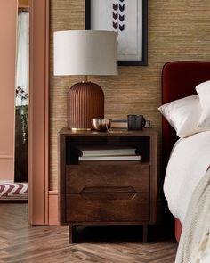 a bedroom with a bed, nightstand and mirror