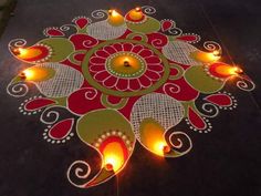 a decorated floor with candles on it and an intricate design in the shape of a flower