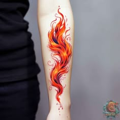 a woman's arm with an orange and red fire tattoo on it