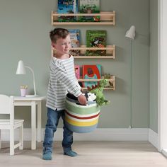 a young boy is holding a toy in a room