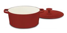 a red pot with a lid sitting next to a white plate on a white background