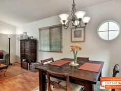 a dining room table and chairs in front of a window