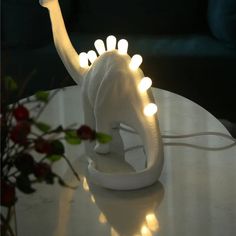 an elephant with lights on it's head sitting on a table