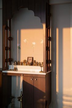 a bathroom sink sitting under a mirror next to a wooden cabinet and wall mounted faucet