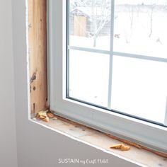 the window is being installed on the side of the house in order to see what's inside