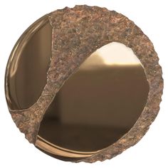 a round mirror that is made out of metal and has a brown pattered surface