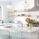 a large kitchen with white cabinets and blue chairs in front of the counter top area