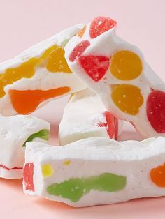 several pieces of candy sitting on top of each other in front of a pink background