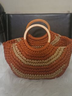 an orange and beige purse sitting on top of a white furnishing covered floor