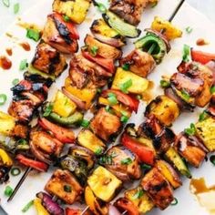 grilled vegetables and meat on a white platter with chopsticks next to it