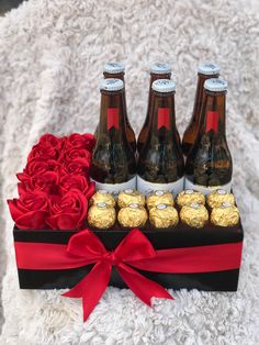 four bottles of beer and roses in a box