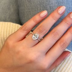 a woman's hand with a diamond ring on it